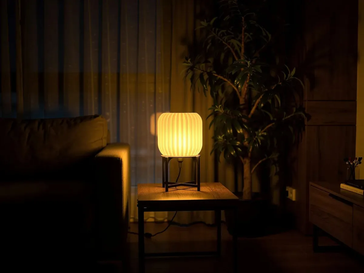 LampuKita lamp in a living room setting, warm glow creating cozy atmosphere